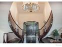 Stunning foyer with curved staircase, and grand chandelier at 8337 Greenwood Dr, Niwot, CO 80503
