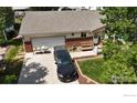 Charming home with an attached garage, front yard, and black SUV parked in the driveway at 106 Keep Cir, Berthoud, CO 80513