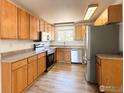 Bright kitchen with wooden cabinets, stainless steel appliances, and wood-look flooring at 11941 S Clayson St, Parker, CO 80138