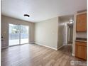 Open concept living room with wood-look floors and sliding glass doors to the patio at 11941 S Clayson St, Parker, CO 80138