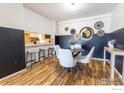 Chic dining area with modern decor, wood floors, and a breakfast bar, blending style and functionality seamlessly at 12114 Melody Dr, Denver, CO 80234