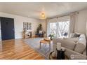 Stylish living room showcasing hardwood floors, a cozy couch, and a balcony, perfect for relaxing and entertaining at 12114 Melody Dr, Denver, CO 80234