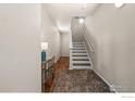 Bright hallway featuring a staircase, mirrored table, and hardwood floors at 1703 Whitehall Dr # G, Longmont, CO 80504