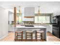 Modern kitchen with stainless steel appliances, quartz countertops, stylish backsplash, and an island with barstool seating at 3089 S Jasmine St, Denver, CO 80222
