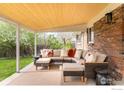 Covered outdoor patio with a comfortable sectional sofa, perfect for relaxing and entertaining in a landscaped backyard at 3089 S Jasmine St, Denver, CO 80222