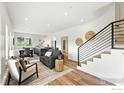 Open-concept living room with modern decor, hardwood floors, and staircase with black iron railing at 360 Boulder St, Boulder, CO 80302