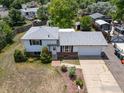Aerial view of a house with a new roof and a spacious driveway and mature landscaping at 3792 E 114Th Dr, Thornton, CO 80233