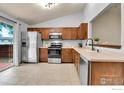 Bright kitchen with stainless steel appliances, tile floor, and ample cabinet space at 5493 Bobcat St, Frederick, CO 80504