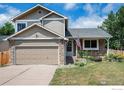 Charming two-story home featuring stone accents, a manicured lawn, and a welcoming front porch with an American flag at 6019 S Pierson Ct, Littleton, CO 80127