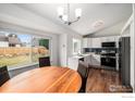 Bright eat-in kitchen with white cabinets, stainless steel appliances, and a stylish blue backsplash for a modern touch at 6019 S Pierson Ct, Littleton, CO 80127
