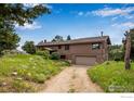 Spacious home with a front yard and a driveway that leads to a garage at 853 Deer Trail Rd, Boulder, CO 80302
