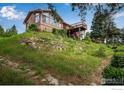 Charming home featuring a walkout basement, deck, and natural rock landscaping at 853 Deer Trail Rd, Boulder, CO 80302