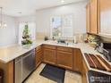 Well-lit kitchen featuring warm wood cabinetry, durable countertops, and stainless steel appliances at 12912 Grant E Cir # A, Thornton, CO 80241