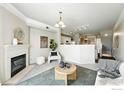 Cozy living room with fireplace, plush seating, and view into adjacent kitchen area at 1876 Mallard Dr, Louisville, CO 80027