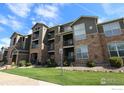 Attractive apartment complex with stone accents, balconies, and well-maintained landscaping at 3155 Blue Sky Cir # 16-103, Erie, CO 80516