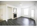 Bright living room with vinyl plank flooring, a cozy fireplace, and a patio door at 3155 Blue Sky Cir # 16-103, Erie, CO 80516