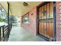 Close-up of a covered front porch with brick walls and a decorative security door at 610 S Miller Ave, Lafayette, CO 80026