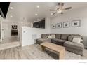 Bright living room with a sectional sofa, wood-look floors, and open layout at 619 Brennan Cir, Erie, CO 80516