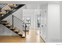 Modern staircase featuring wooden steps, a metal banister and bright white walls at 6668 Walker Ct, Niwot, CO 80503