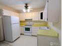 Compact kitchen with white appliances and functional layout at 7040 E Girard Ave # 103, Denver, CO 80224