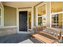 Charming front porch with bench seating and large windows at 8305 E 149Th Dr, Thornton, CO 80602
