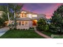 Charming two-story home boasts manicured lawn, mature trees, and brick accents during dusk hours at 888 Northern Way, Superior, CO 80027