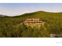 Secluded mountain home nestled among towering trees and lush vegetation on a sun-kissed hillside at 11780 Gold Hill Rd, Boulder, CO 80302