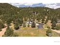 Aerial view of the house nestled in a beautiful, tree-filled landscape with a long driveway at 514 Granite Dr, Boulder, CO 80302