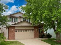 Charming two-story home featuring a brick facade and a well-maintained front yard at 13661 Adams St, Thornton, CO 80602