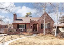 Charming brick home with a well-maintained front yard and classic architectural details at 1675 Newport St, Denver, CO 80220