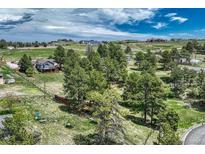 Expansive aerial view of a home nestled amongst mature trees in a serene, sprawling landscape at 10534 Inspiration Dr, Parker, CO 80138