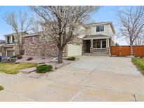 Charming two-story home featuring a brick facade, covered porch, and well-manicured front yard at 20875 E Girard Pl, Aurora, CO 80013