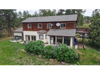 Two-story home featuring wood siding, daylight basement, and a well-maintained front yard at 2545 N State Highway 67, Sedalia, CO 80135