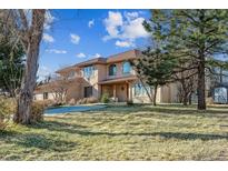 Two-story home with a landscaped yard, portico, and a beautiful brown tile roof at 8544 Burning Tree Trl, Franktown, CO 80116