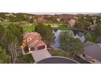 Stunning home with a large driveway, lovely landscaping, and beautiful view of the community golf course and pond at 3216 Country Club Pkwy, Castle Rock, CO 80108
