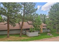 Charming exterior view of the home showcasing natural landscaping and stone chimney at 2378 Hearth Dr # 20, Evergreen, CO 80439