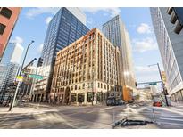 Street-level view of the building's exterior, showcasing the architectural details and surrounding cityscape on a sunny day at 444 17Th St # 208, Denver, CO 80202