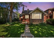 Charming brick home featuring a well-maintained front yard with mature tree and inviting walkway at 521 Harrison St, Denver, CO 80206