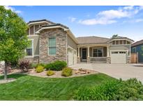 Charming home with a stone and siding exterior, well-manicured lawn, and a three-car garage at 10182 Bristleridge St, Parker, CO 80134