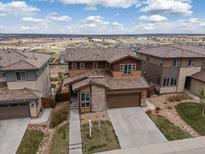 Beautiful two-story home with a stone facade, well-manicured lawn, and a two-car garage at 14710 Domino Dr, Parker, CO 80134