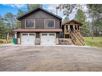 Charming two-story home featuring a two-car garage and detached covered porch with stairs at 33844 Oriole Ct, Elizabeth, CO 80107