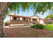 Charming ranch-style home with brick facade, red shutters and landscaped front yard at 6336 W 71St Pl, Arvada, CO 80003