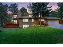 Charming two-story home featuring a well-manicured lawn and a spacious deck, perfect for outdoor entertaining at 1540 Fawnwood Rd, Monument, CO 80132