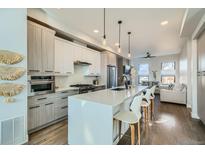 Bright, modern kitchen featuring stainless steel appliances, pendant lighting, a spacious island, and hardwood floors at 2475 E 28Th Ave, Denver, CO 80205