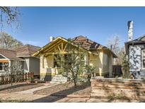 Charming bungalow with yellow accents, covered porch, and inviting curb appeal at 2421 Hooker St, Denver, CO 80211