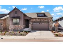 Charming two-story home featuring a stone and wood facade, landscaped front yard and a two-car garage at 8052 Mount Kataka St, Littleton, CO 80125