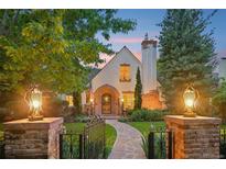 Charming Tudor home with a brick walkway, manicured lawn, and beautifully lit exterior at 5530 E 6Th Avenue Pkwy, Denver, CO 80220