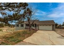 Charming single-Gathering home featuring a two-car garage, covered front porch, and landscaped front yard at 1233 Starling Ln, Elizabeth, CO 80107