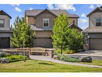 Charming two-story home featuring a bench in the front yard with lush landscaping and an attached two-car garage at 10401 Maplebrook Way, Highlands Ranch, CO 80126