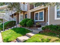 Charming townhome featuring a well-manicured lawn, brick facade, and inviting entrance stairs at 4676 S Dillon Ct # G, Aurora, CO 80015